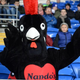 Nando's chicken mascot sitting in stands at sporting event